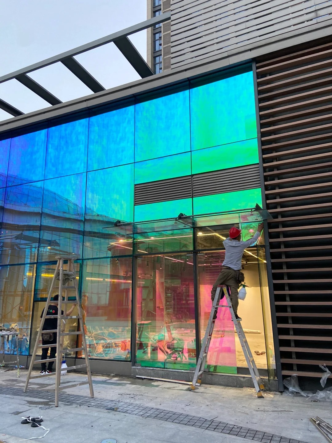 Blue dichroic film being installed on a commercial glass façade